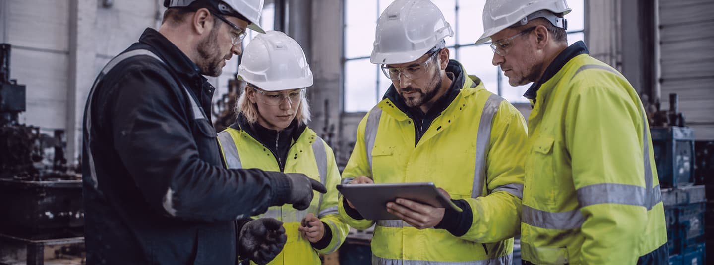 Team som gjennomgår et reelt arbeidsscenario sammen på et nettbrett